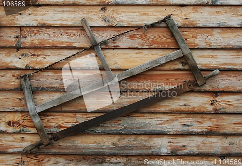 Image of An old saw hangs on the wall