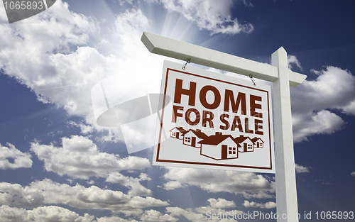 Image of White Home For Sale Real Estate Sign Over Clouds and Sky