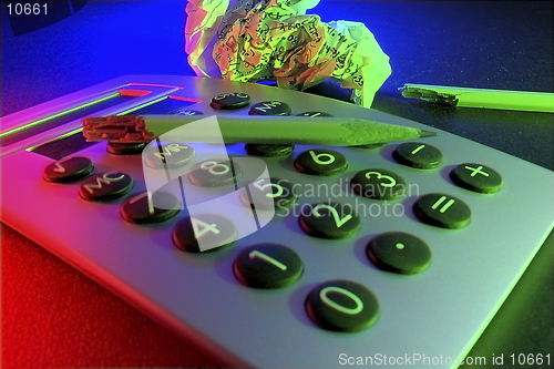 Image of A business/educational still life with calculator, broken pencil and wad of paper with figures, representing stress and frustration.  Even the sawdust from the snapped pencil remains...