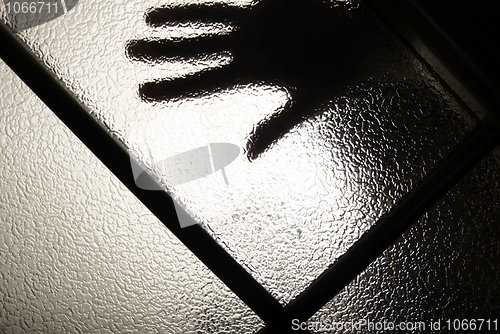 Image of hand behind the glass   