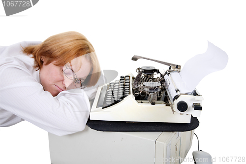 Image of Woman sleeping on a workplace with a typewriter