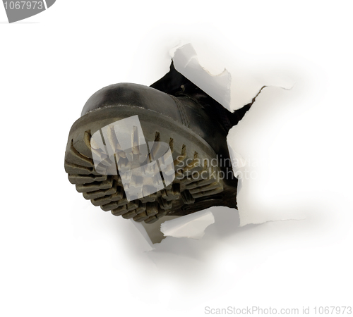 Image of Male black boot in hole of paper 