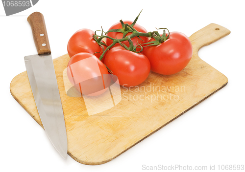 Image of Red tomatoes and kitchen knife on a chopping board