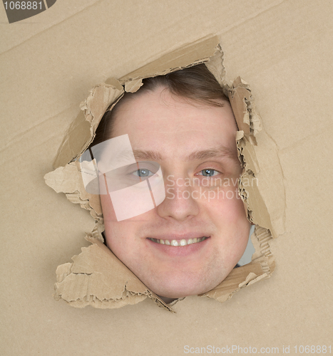 Image of Male face look up through hole carton