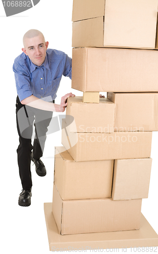 Image of Man pushing heap from cardboard boxes