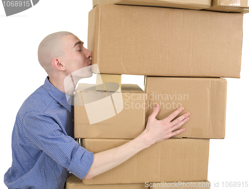 Image of Man kisses heap cardboard boxes