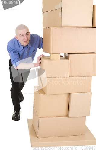 Image of Man pushing heap from cardboard boxes