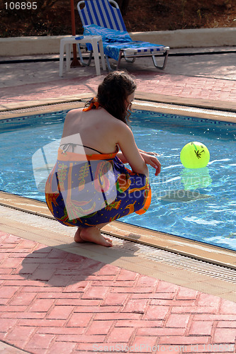 Image of Girl next to blue swimming pool ...