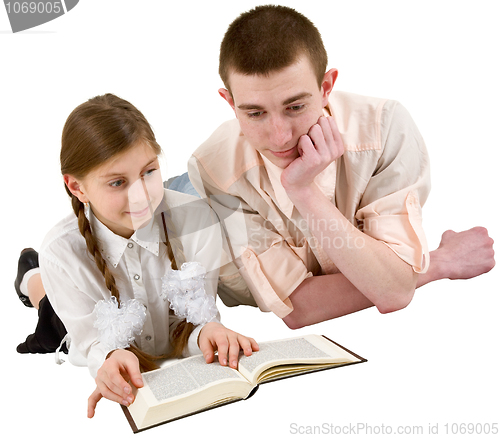 Image of Girl and young man reading book in a reclining position