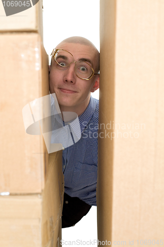 Image of Male face clamping between cardboard boxes