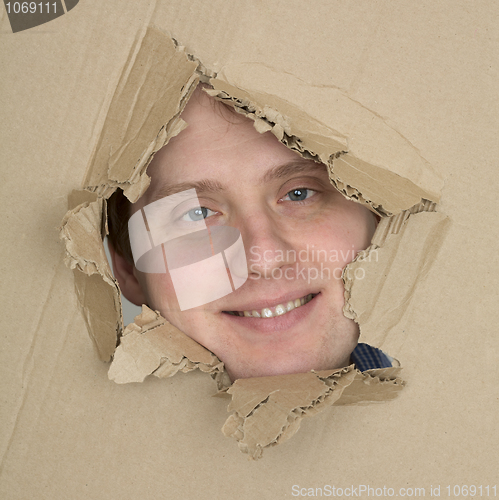 Image of Male face look up from hole in carton 