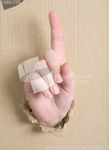 Image of Gesture male hand through cardboard