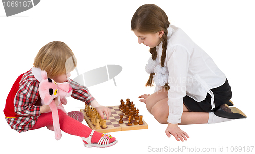 Image of Girl teaching little girl play chess
