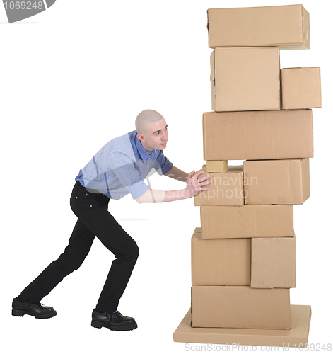 Image of Man pushing pile cardboard boxes
