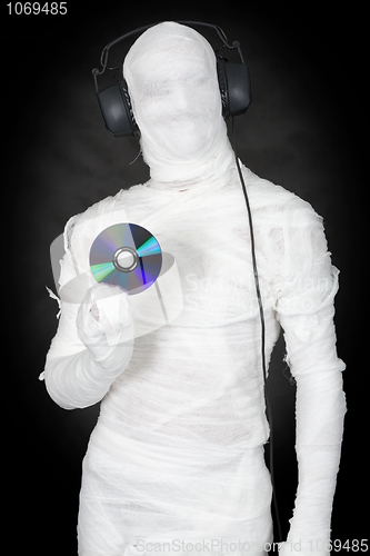 Image of Man in bandage with ear-phones and disc