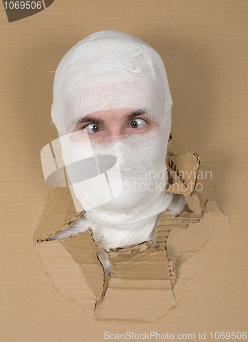 Image of Male face on bandage in carton hole