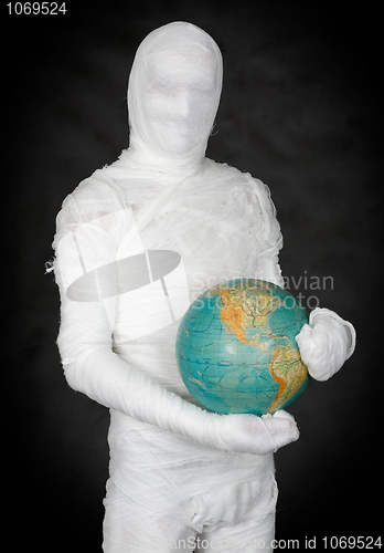 Image of Man in costume mummy and terrestrial globe