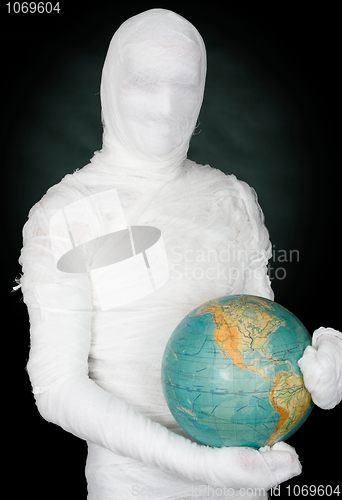 Image of Man in costume mummy and terrestrial globe 