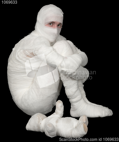 Image of Egyptian mummy emo sitting on a black