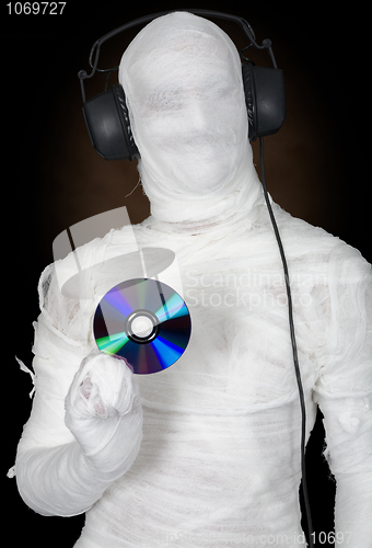 Image of Man in bandage with ear-phones and disc