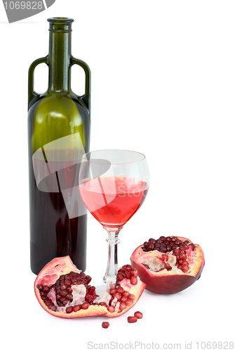 Image of Glass of wine, bottle and a red pomegranate