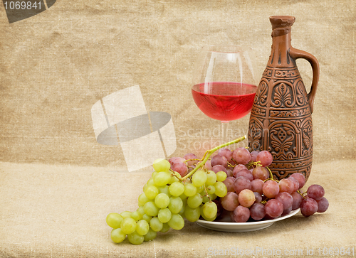 Image of Ceramic brown bottle, grapes and goblet