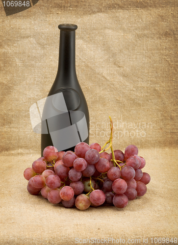 Image of Dark bottle and red grapes bunch