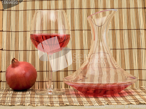 Image of Glass of wine, decanter and pomegranate