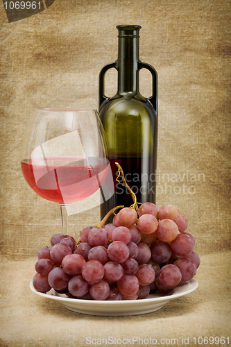 Image of Green bottle, goblet and grapes