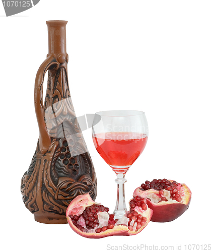 Image of Glass of wine, bottle and a red pomegranate