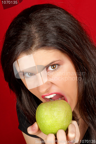 Image of Angry young woman with green apple