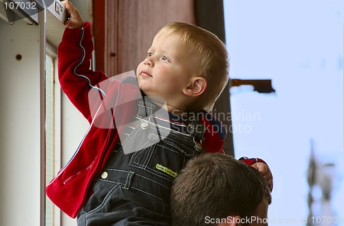 Image of two year old boy siting on his dad`s  neck.