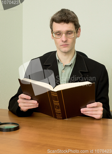 Image of Guy in eyeglasses reads the book