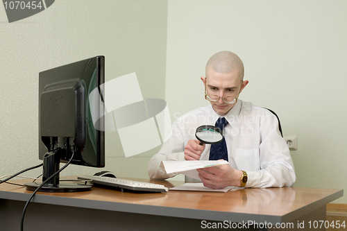 Image of Boss with a magnifier on a workplace