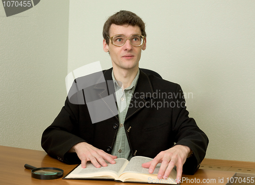 Image of Guy in eyeglasses reads the book