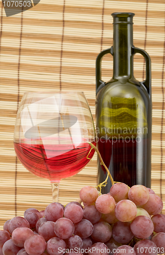 Image of Glass bottle, goblet and grape