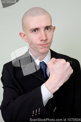 Image of Man in a suit threatens with a fist