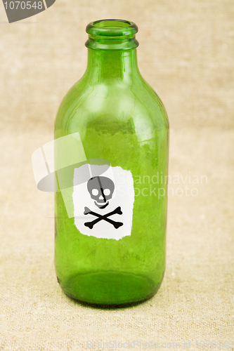Image of Green bottle with sticker skull and crossbones