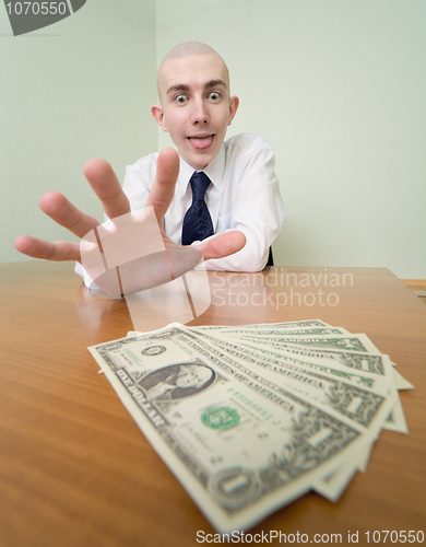 Image of Man reaches for a batch of money