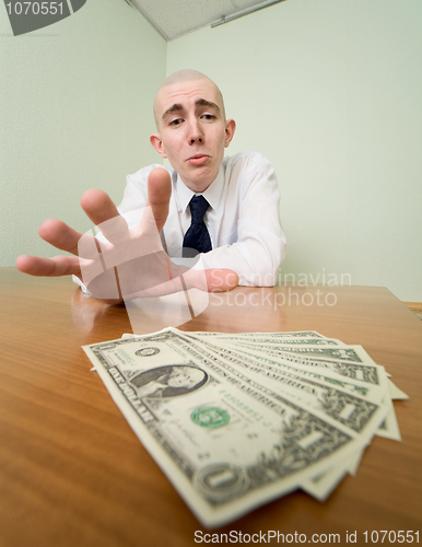 Image of Man reaches for a batch of money