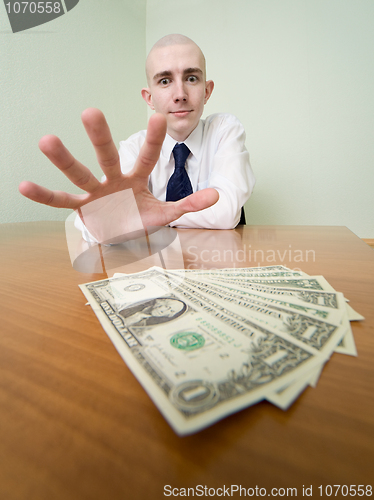 Image of Man reaches for a batch of money