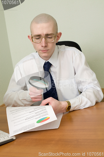 Image of Boss with a magnifier on a workplace