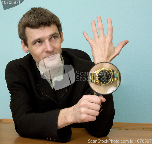 Image of Person view a watch through a magnifier