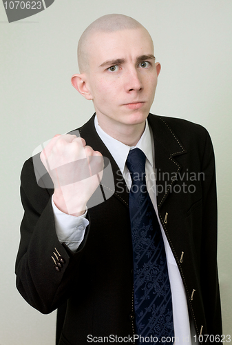 Image of Man in a suit threatens with a fist