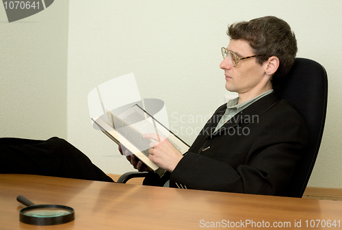 Image of Guy in eyeglasses reads the book