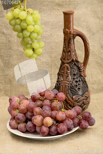 Image of Ceramic bottle and grapes 