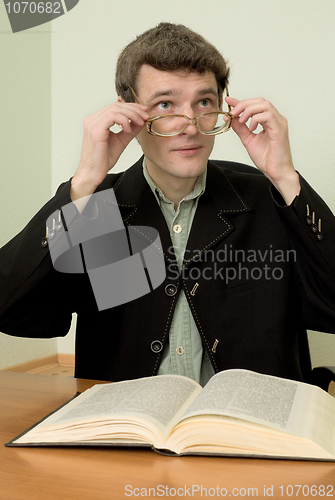 Image of Guy in eyeglasses reads the book