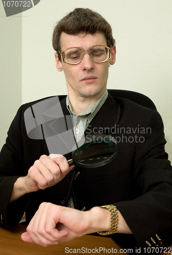 Image of Person view a watch through a magnifier