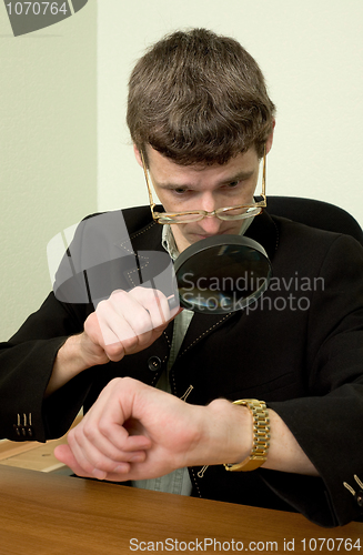 Image of Person view a watch through a magnifier