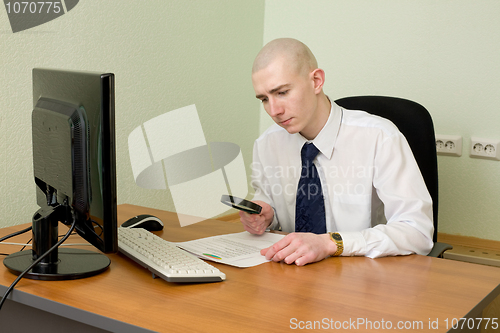 Image of Businessman with a magnifier on a workplace